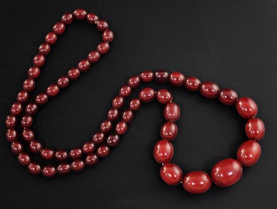 A single strand graduated simulated cherry amber oval bead necklace, 68cm.